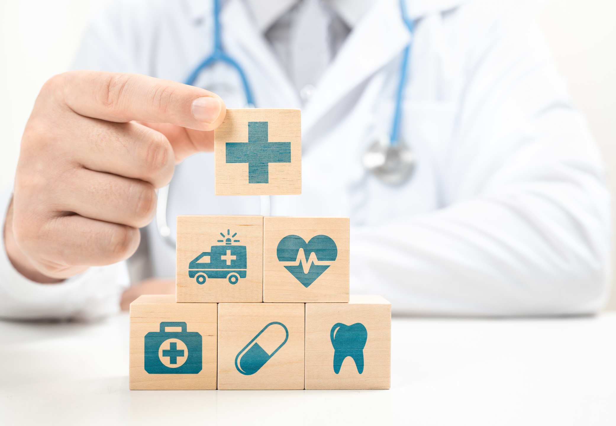 mão de médico segurando alguns dados com figuras sobre saúde