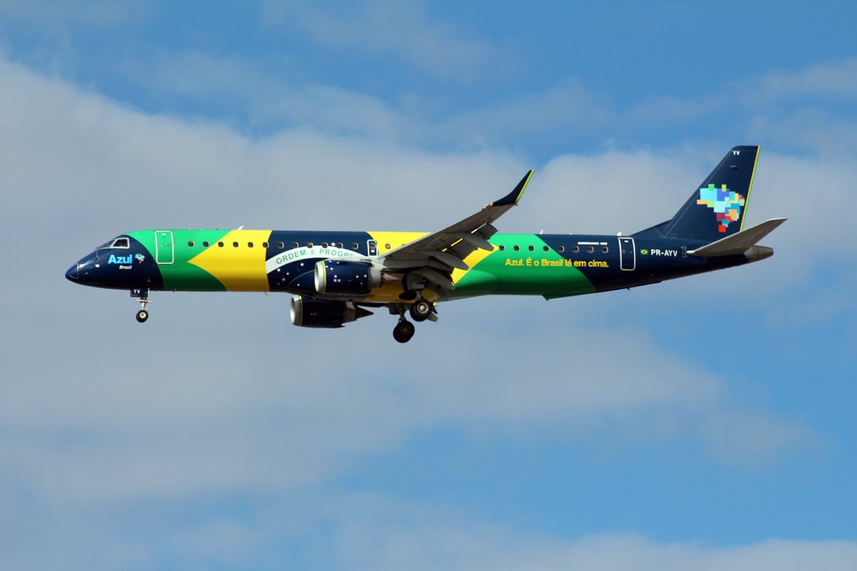 avião ao lado da bandeira do brasil