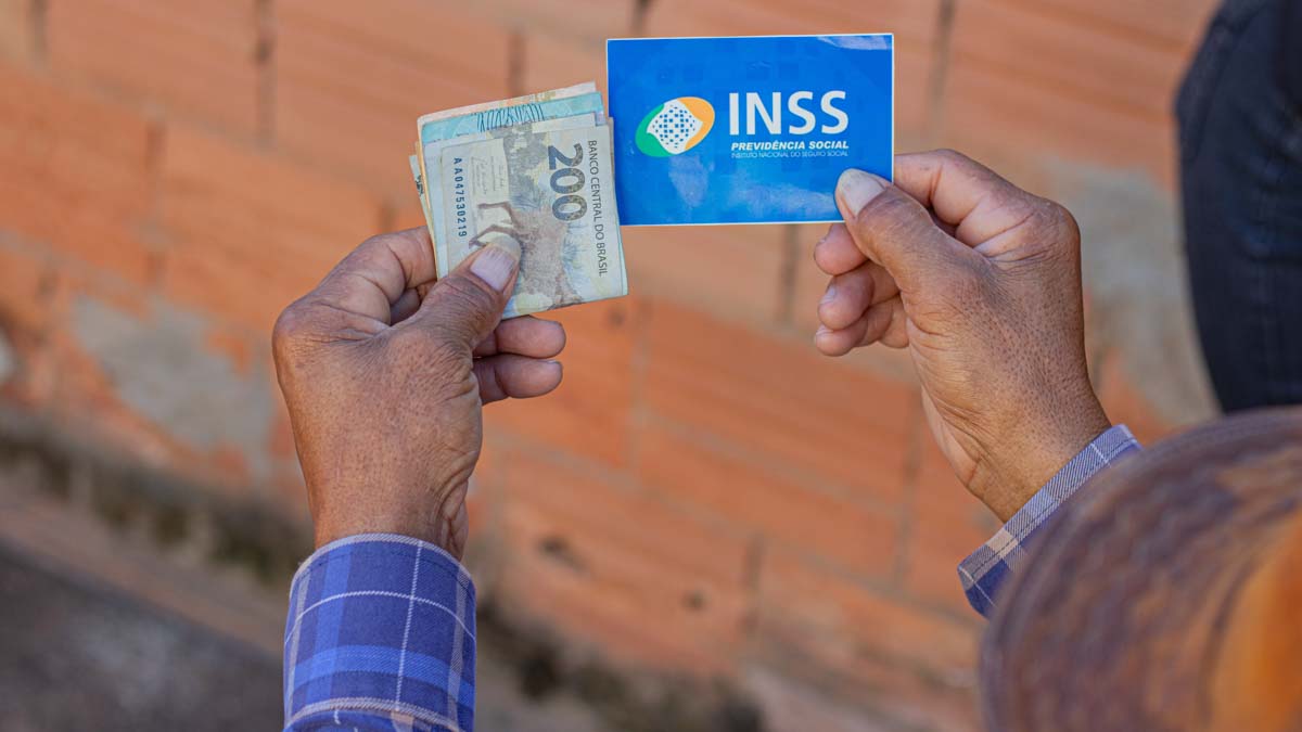 aposentado segurando dinheiro e cartão do inss