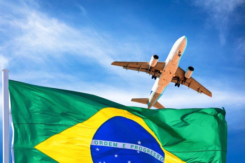 avião no céu ao lado da bandeira do Brasil